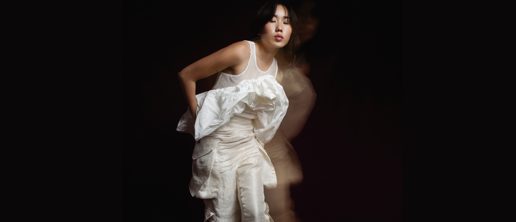 Person wearing a white dress against a dark background